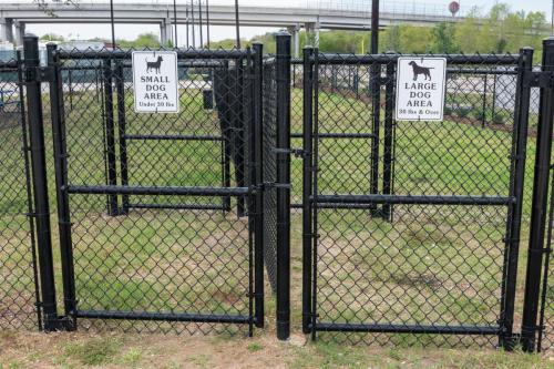 The entrance of the dog park at the Medical Center RV Resort in Houston, Texas with separate black gates for small dogs and large dogs.